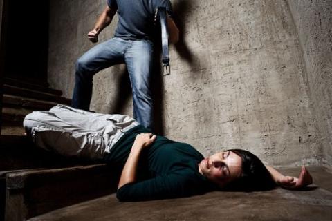 Täter mit Gürtel und Opfer liegend auf Treppe
