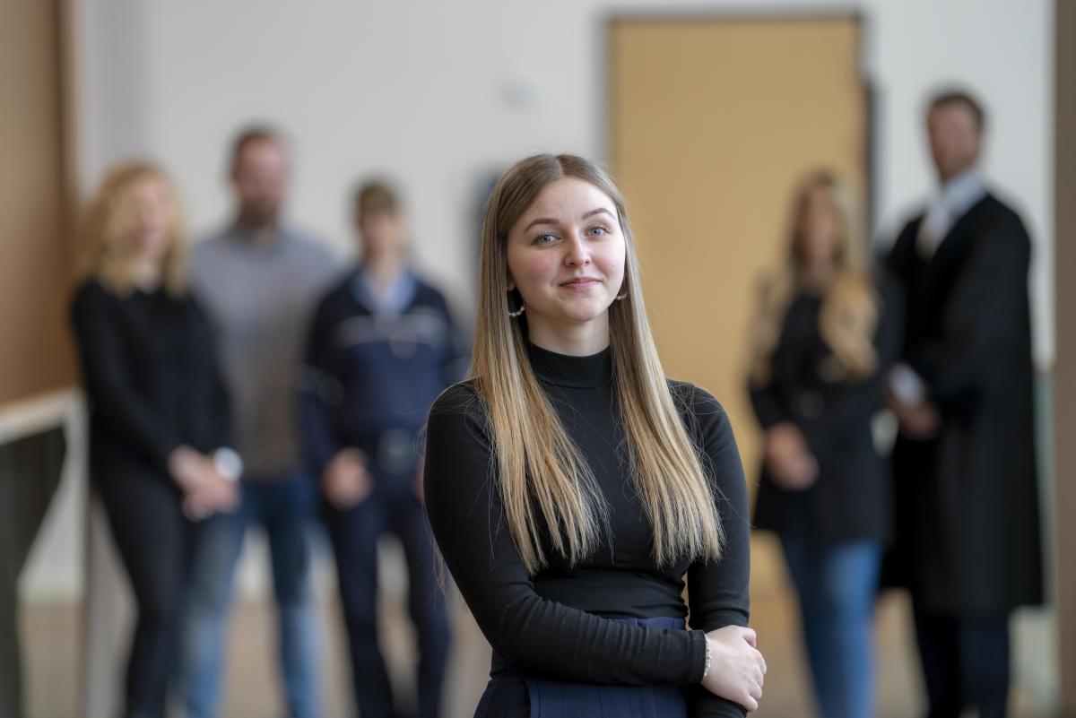 Justizfachangestellte vor Gruppe mit Justizmitarbeiter/-innen