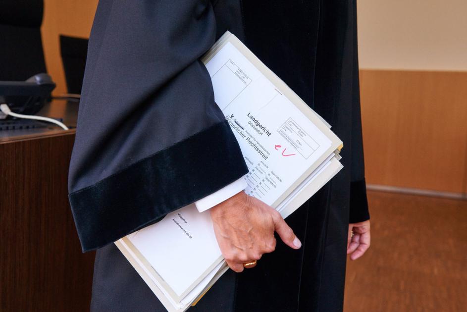 Frau in Robe im Gerichtssaal mit Zivilakte