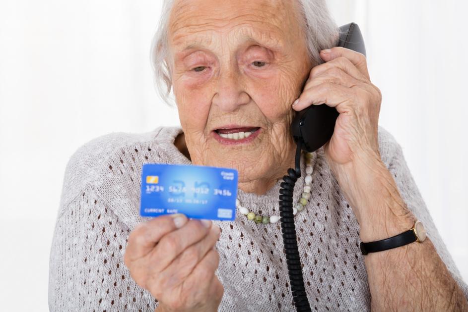 Seniorin mit Kreditkarte und Telefon