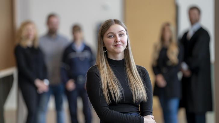 Justizfachangestellte vor Gruppe mit Justizmitarbeiter/-innen