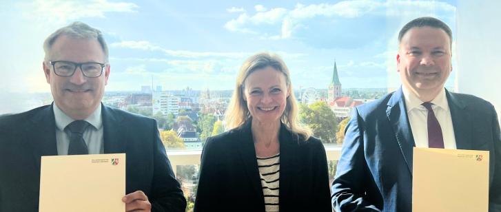 drei Personen vor einem Fenster