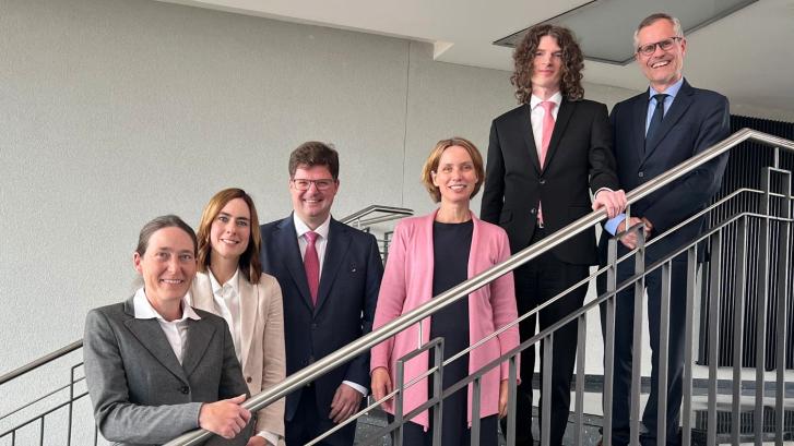 drei Personen vor einem Fenster