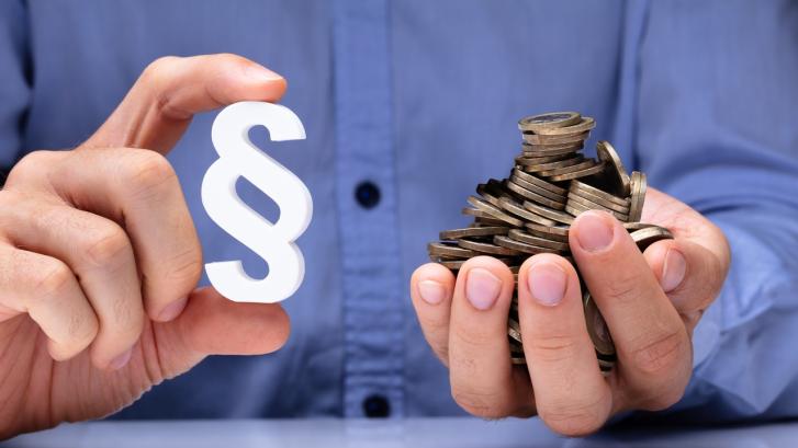 Hände mit Paragraphenzeichen und Geld