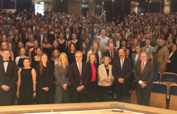 Gruppenfoto der Diplomierungsfeier 2024: Absolventinnen und Absolventen zusammen mit den Ehrengästen und Dozierenden im Stadttheater Euskirchen